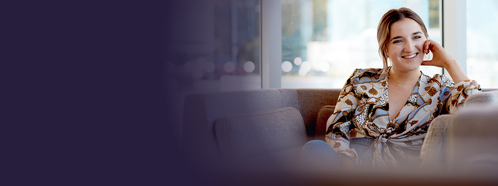 A student sitting in one of the social spaces on Keele University campus